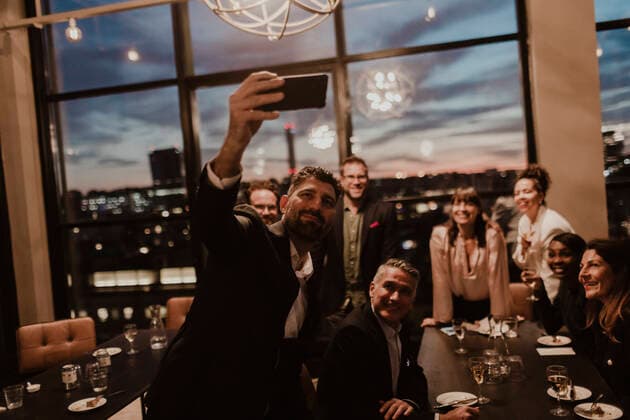 Smiling business people taking selfie on mobile phone at office during party Sweden, Stockholm, model released, property released Copyright: xMaskotx , MA84622