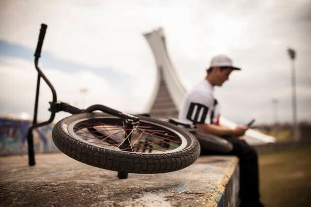 Bmxer sitting on top of ramp using mobile phone Montreal, QC, Canada CR_CHPH210303C-621330-01 ,model released, Symbolfoto