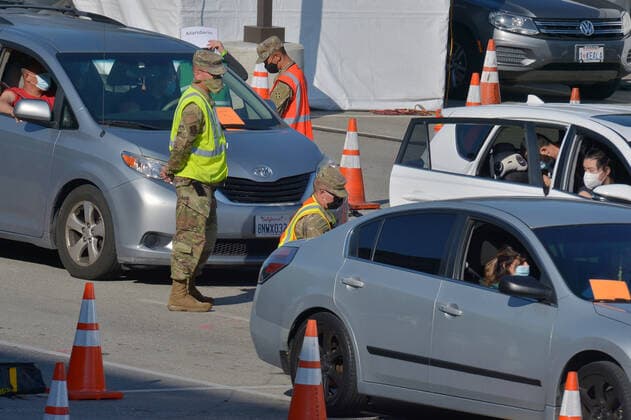 Military personnel administer COVID-19 shots to local residents at a drive-through vaccination site on the Cal State LA campus in Los Angeles on Thursday, March 4, 2021. California will begin sending 40% of all vaccine doses to the most vulnerable neighborhoods in the state to try to inoculate people most at risk from the coronavirus and get the state s economy open more quickly, Gov. Gavin Newsom said Thursday in the latest shake-up to the state s rules.  LAP2021030433 JIMxRUYMEN