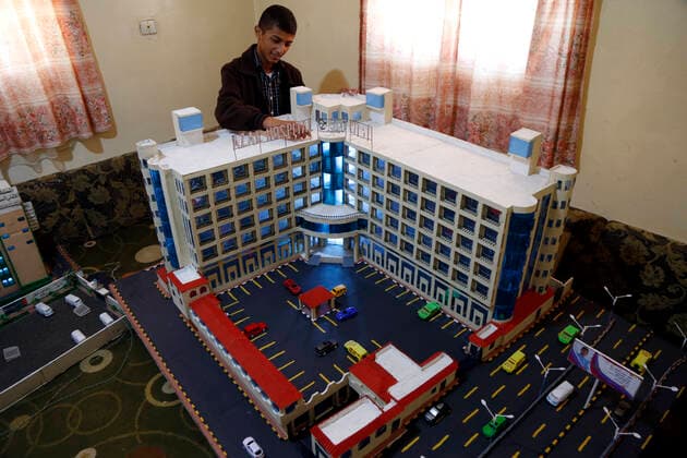 (210306) -- SANAA, March 6, 2021 -- Musheer Al-Hzmi, stands beside the building models he built inside his house in Sanaa, Yemen, on March 4, 2021. TO GO WITH Feature: Yemeni boy makes building models to recreate Sanna before war (Photo by Xinhua) YEMEN-SANAA-BUILDING MODELS MohammedxMohammed 