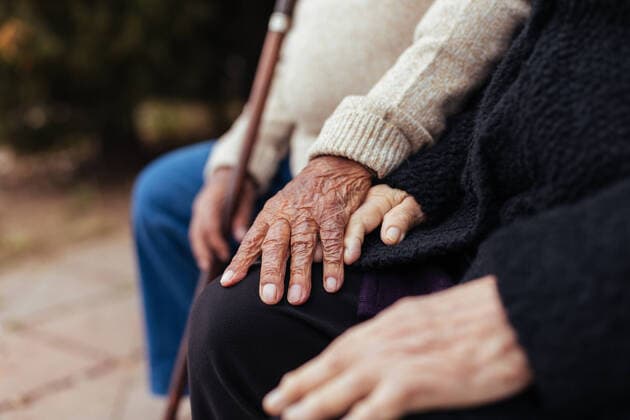 Creative Highlights Symbolbilder Crop of anonymous elderly couple holding hands while sitting on a park bench, Model released Copyright: xMarcosxOsoriox MR