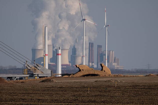A picture of contrasts. Fossil and renewable energy use side by side. Wind turbines, a lignite power plant that sends its water vapor into the sky and bucket wheel excavators next to each other near the Garzweiler II mining area. In Luetzerath on March 6, 2021 GERMANY - ERKELENZ - LUETZERATH - COAL WASWESTOPOULOS-2021 3 6-1