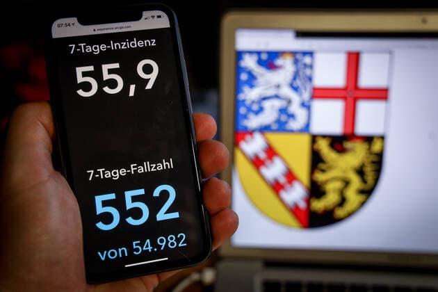 Coronavirus in Deutschland - Covid-19-Dashboard des Robert Koch-Institut DEU, Deutschland, Saarland, 07.03.2021: Die 7-Tage-Inzidenz für das Bundesland (Fälle letzte 7 Tage 100.000 EW) wird auf einem iPhone angezeigt, im Hintergrund das Landeswappen