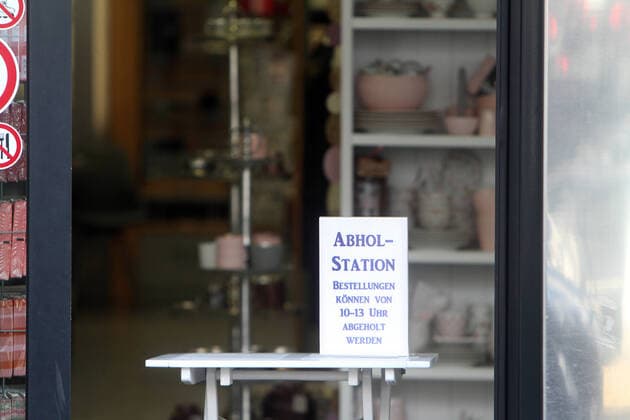 Schild mit Aufschrift Abholstation Bestellungen können von 10 - 13 Uhr abgeholt werden steht auf einem Tisch im Eingangsbereich eines geschlossenen Geschäfts in der Innenstadt von Hofheim, Hessen, Deutschland
