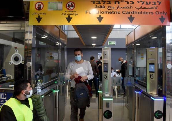 Palestinian workers wait in line to receive the first dose of the Moderna COVID-19 vaccine at the Lamed Hei Checkpoint between Gush Etzion and Beit Shemesh, on Monday, March 8, 2021. Israel started a two week campaign to vaccine some 100,000 Palestinian workers from the West Bank who hold permits to work in Israel and Jewish settlements. The vaccination campaign is a joint project by the Israeli Heath Ministry, Ministry of Defense, Land Crossing Authority and the Coordination of Government Activities in the Territories.  JER2021030803 DEBBIExHILL