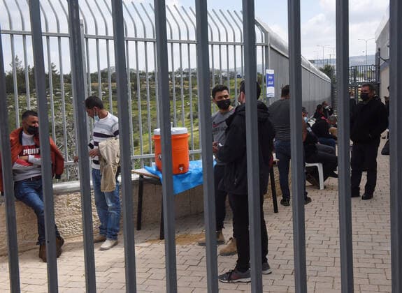 Palestinian workers wait fifteen minutes after receiving the first dose of the Moderns COVID-19 vaccine at the Lamed Hei Checkpoint between Gush Etzion and Beit Shemesh, on Monday, March 8, 2021. Israel started a two week campaign to vaccine some 100,000 Palestinian workers from the West Bank who hold permits to work in Israel and Jewish settlements. The vaccination campaign is a joint project by the Israeli Heath Ministry, Ministry of Defense, Land Crossing Authority and the Coordination of Government Activities in the Territories.  JER2021030813 DEBBIExHILL