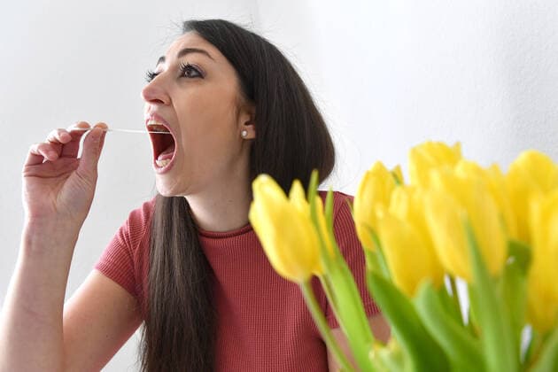 Themenbild Corona Antigen Test,Schnelltest, Coronaschnelltest.Selbsttest. Jeder Bundesbuerger soll einen Anspruch auf einen kostenlosen Schnelltest pro Woche haben. Eine junge Frau fuehrt einen Selbstest aus und macht einen Rachenabstrich zu Hause, MODEL RELEASED!