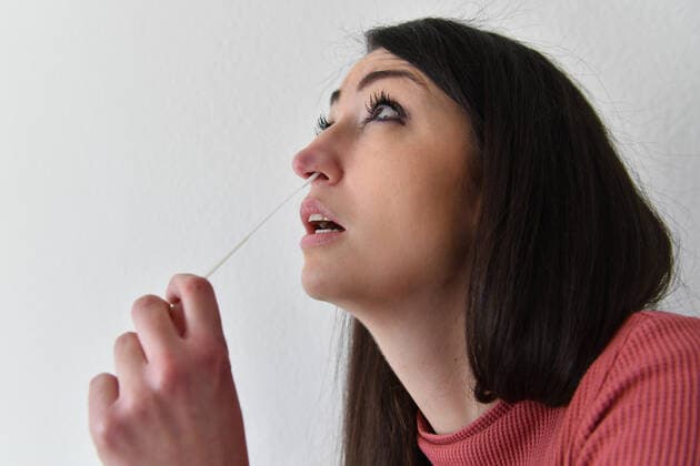 Themenbild Corona Antigen Test,Schnelltest, Coronaschnelltest.Selbsttest. Jeder Bundesbuerger soll einen Anspruch auf einen kostenlosen Schnelltest pro Woche haben. Eine junge Frau fuehrt einen Selbstest aus und macht einen Nasenabstrich zu Hause. MODEL RELEASED!