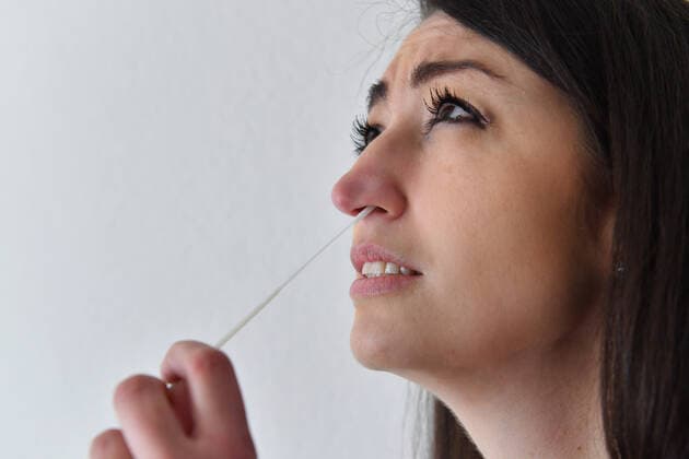 Themenbild Corona Antigen Test,Schnelltest, Coronaschnelltest.Selbsttest. Jeder Bundesbuerger soll einen Anspruch auf einen kostenlosen Schnelltest pro Woche haben. Eine junge Frau fuehrt einen Selbstest aus und macht einen Nasenabstrich zu Hause. MODEL RELEASED!