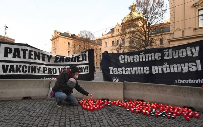 A woman, wearing respirator to prevent the spread of the coronavirus, lays down candle during the rally of group Let Us Stop COVID called Let Us Save Lives, Let Us Stop Industry in front of the Government Office in Prague, Czech Republic, March 9, 2021. (CTKxPhoto MichaelaxRihova) CTKPhotoP202103090776001  mir 2