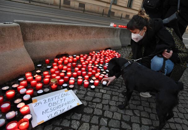 A woman, wearing respirator to prevent the spread of the coronavirus, lays down candle during the rally of group Let Us Stop COVID called Let Us Save Lives, Let Us Stop Industry in front of the Government Office in Prague, Czech Republic, March 9, 2021. (CTKxPhoto MichaelaxRihova) CTKPhotoP202103090794001  mir 6