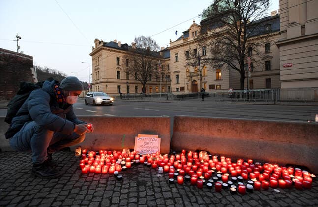 A man, wearing respirator to prevent the spread of the coronavirus, lays down candle during the rally of group Let Us Stop COVID called Let Us Save Lives, Let Us Stop Industry in front of the Government Office in Prague, Czech Republic, March 9, 2021. (CTKxPhoto MichaelaxRihova) CTKPhotoP202103090806201  mir 11