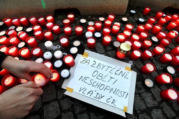 A woman lays down candle during the rally of group Let Us Stop COVID called Let Us Save Lives, Let Us Stop Industry in front of the Government Office in Prague, Czech Republic, March 9, 2021. (CTKxPhoto MichaelaxRihova) CTKPhotoP202103090814401  mir 13