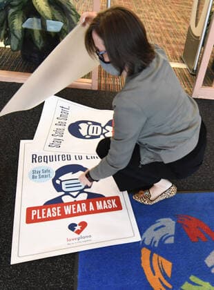 Workers at a public library in Plano, Texas change out signs requiring mask to enter on Tuesday, March 9, 2021 in preparation for changes in the state s mask mandate. Texas Gov. Greg Abbott fully rescinded the statewide mask order and is allowing business to reopen at full capacity effective March 10, 2021 leaving organizations and businesses to determine if they want to require customers to wear masks or not.  DAL2021030904 IANxHALPERIN