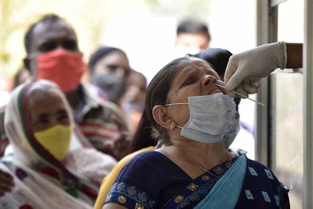 NOIDA, INDIA - MARCH 9: A health worker collects a swab sample from a woman for Covid-19 test, at Sector 30 District Hospital, on March 9, 2021 in Noida, India. (Photo by Sunil Ghosh Hindustan Times )