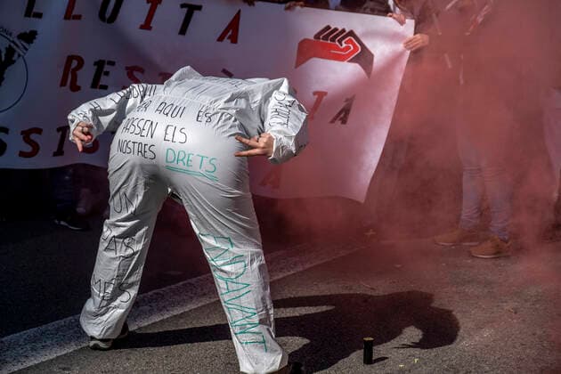 March 10, 2021, Barcelona, Catalonia, Spain: A protester at Via Laietana gestures as she shows the back of her PPE with written messages, during the demonstration..Under the slogan estemfartes (we are fed up), the Catalan Health Union Board, formed by minority unions, has mobilized health workers to a day of strike to denounce the physical fatigue of health professionals and salary cuts. Barcelona Spain - ZUMAs197 20210310_zaa_s197_151 Copyright: xPacoxFreirex