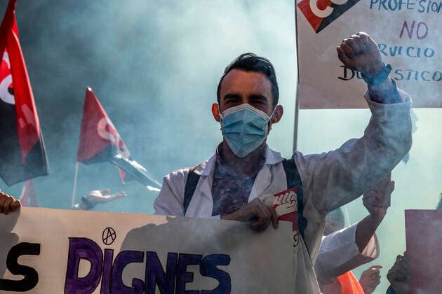 March 10, 2021, Barcelona, Catalonia, Spain: A protester at Plaza Sant Jaume raising his fist amid smoke during the demonstration..Under the slogan estemfartes (we are fed up), the Catalan Health Union Board, formed by minority unions, has mobilized health workers to a day of strike to denounce the physical fatigue of health professionals and salary cuts. Barcelona Spain - ZUMAs197 20210310_zaa_s197_157 Copyright: xPacoxFreirex