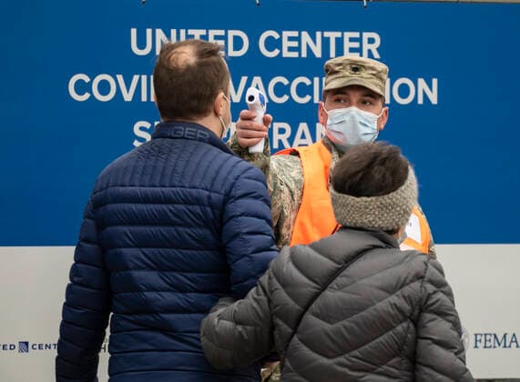 (210310) -- CHICAGO, March 10, 2021 -- A man has his temperature taken before entering a mass COVID-19 vaccination site at the United Center in Chicago, the United States, on March 10, 2021. The mass COVID-19 vaccination site started running at the arena on Tuesday. (Photo by Xinhua) U.S.-CHICAGO-MASS VACCINATION SITE-OPENING JoelxLerner 
