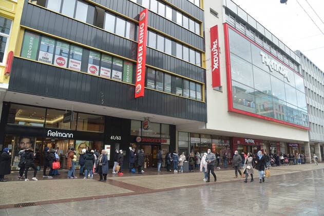 Die Saarbrücker Bahnhofstraße zeigt sich am Donnerstag (11.03.2021) belebt. Das Oberverwaltungsgericht des Saarlandes hat in einem Urteil einige Corona-Beschränkungen für den Einzelhandel vorläufig gekippt. So entfällt ab sofort die Pflicht zur Terminvergabe und pro Kunde sind nur noch 15 Quadratmeter nötig. Im Bild: Lange Warteschlange vor TK Maxx.