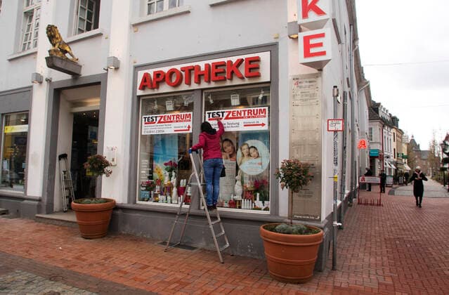 Die Moerser Innenstadt in Corona-Zeiten Blick in die Moerser Fussgängerzone in Corona-Zeiten. Die Moerser Löwen Apotheke bietet kostenlose Corona Teste an. Die Mitarbeiterinnen bringen Wegweiser und Werbeplakate für die Testung an. Mit der Aufschrift: Test-Zentrum - Kostenfreie Testung nach Verordnung des Bundes. Moers Deutschland Nordrhein-Westfalen