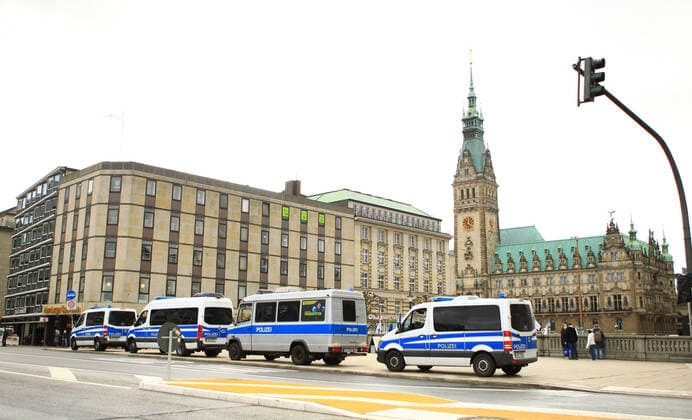 Einsatzwagen der Polizei stehen an der Reesendammbrücke am Hamburger Jungfernstieg. Im Hintergrund das Hamburger Rathaus. Die Polizeikräfte bereiten sich auf eine Demonstration von Kritikern der Corona-Politik der Bundesregierung vor, die auf dem Rathausplatz stattfinden wird. Innenstadt Hamburg
