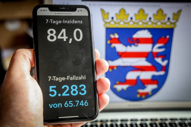 Coronavirus in Deutschland - Covid-19-Dashboard des Robert Koch-Institut DEU, Deutschland, Hessen, 14.03.2021: Die 7-Tage-Inzidenz für das Bundesland (Fälle letzte 7 Tage 100.000 EW) wird auf einem iPhone angezeigt, im Hintergrund das Landeswappen