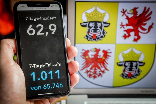 Coronavirus in Deutschland - Covid-19-Dashboard des Robert Koch-Institut DEU, Deutschland, Mecklenburg-Vorpommern, 14.03.2021: Die 7-Tage-Inzidenz für das Bundesland (Fälle letzte 7 Tage 100.000 EW) wird auf einem iPhone angezeigt, im Hintergrund das Landeswappen