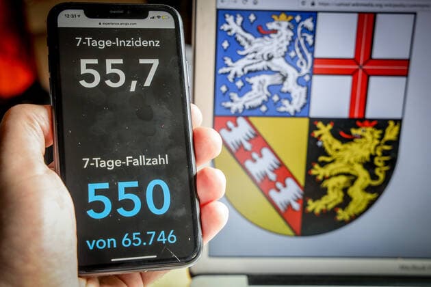 Coronavirus in Deutschland - Covid-19-Dashboard des Robert Koch-Institut DEU, Deutschland, Saarland, 14.03.2021: Die 7-Tage-Inzidenz für das Bundesland (Fälle letzte 7 Tage 100.000 EW) wird auf einem iPhone angezeigt, im Hintergrund das Landeswappen