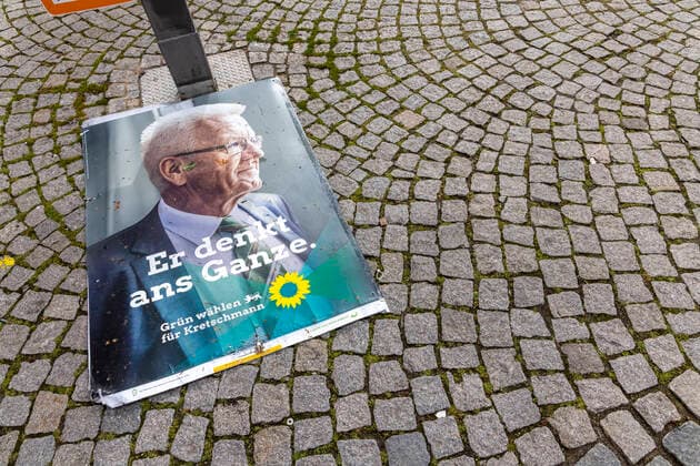 LTWBW21. Der Wind hat sich an Wahlplakaten abgearbeitet. Zahlreiche Plakate, wie hier eines von Ministerpräsident Winfried Kretschmann, liegt auf dem Asphalt. 14.03.2021: Deutschland, Baden-Württemberg, Stuttgart.
