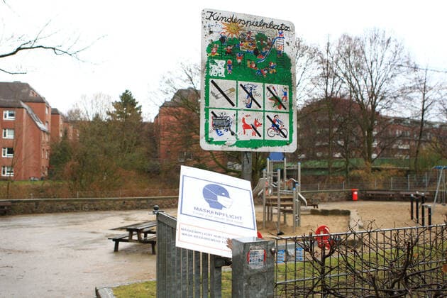 Am Eingang eines Spielplatzes in Hamburg steht ein abgerissenes Schild, das auf die Maskenpflicht für Eltern auf Spielplätzen hinweist. Rund zwei Wochen nach der Anbringung der Schilder sind viele davon abgerissen oder beschmiert worden. Barmbek Hamburg