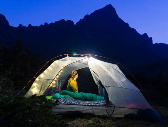 Woman sitting in illuminated tent on mountain at night Crestone, CO, United States CR_BRHU210312A-678789-01 ,model released, Symbolfoto