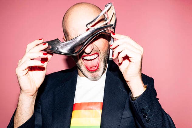 IMAGO Creative: Pride Month, Juni 2022 Creative Highlights Symbolbilder Eccentric bald bearded homosexual male with red lips and manicure in shirt with LGBT flag yelling and covering eyes with high heeled shoe against pink background Copyright: xJosexLuisxCarrascosax Model Released
