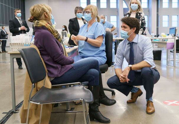 March 15, 2021, Montreal, PQ, Canada: Prime Minister Justin Trudeau chats with a woman about to receive her COVID-19 vaccine while touring a vaccination clinic in Montreal on Monday, March 15, 2021. Montreal Canada  - ZUMAc35_ 20210315_zaf_c35_002 Copyright: xPaulxChiassonx