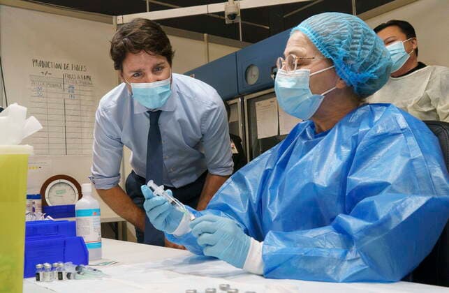 March 15, 2021, Montreal, PQ, Canada: Prime Minister Justin Trudeau watch as a COVID-19 vaccine syringe is prepared as he tours a vaccination clinic in Montreal, on Monday, March 15, 2021. Montreal Canada  - ZUMAc35_ 20210315_zaf_c35_008 Copyright: xPaulxChiassonx