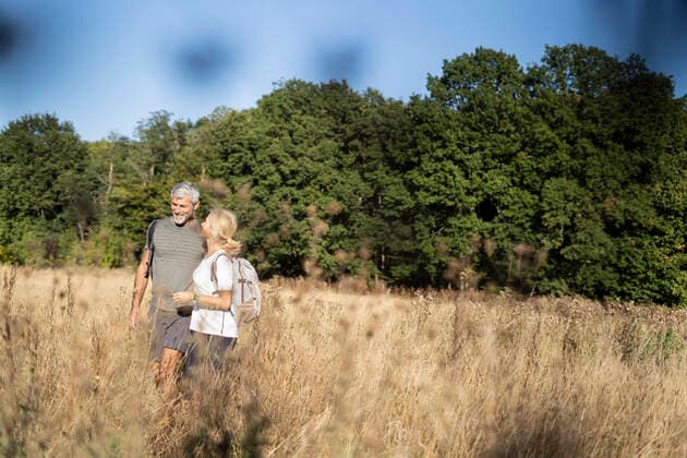 IMAGO Creative: Internationaler Frauenmonat, Gesundheit, Frauen in der Menopause Smiling mature couple hiking in forest Copyright: FrédéricxCirou B56008046