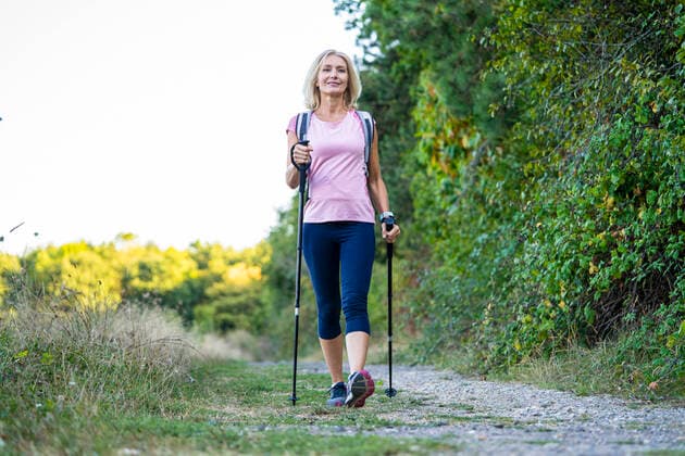 IMAGO Creative: Internationaler Frauenmonat, Gesundheit, Frauen in der Menopause Low angle view of smiling mature woman hiking in forest Copyright: FrédéricxCirou B88303246