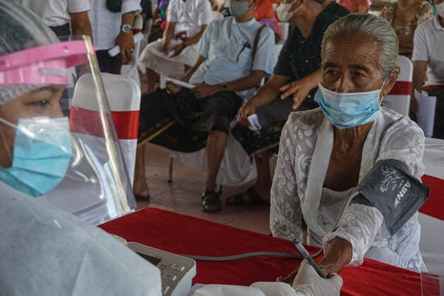 Coronavirus in Indonesien, Präsident Joko Widodo bei Impfstart in Gianyar, Bali March 16, 2021, Gianyar, Bali, Indonesia: A health worker checks a health condition of a citizen before the vaccination. A mass Covid-19 vaccination towards citizens held in Ubud Great Palace, as a stage of Green Zone program in Bali. The Green Zone program involves three region in Bali; Ubud, Sanur and Nusa Dua, are sets to prepare international tourism reopening plan, which falls amid the outbreak. Gianyar Indonesia - ZUMAb245 20210316_zip_b245_001 Copyright: xDickyxBisinglasix