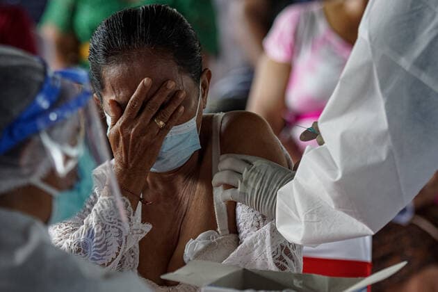 Coronavirus in Indonesien, Präsident Joko Widodo bei Impfstart in Gianyar, Bali March 16, 2021, Gianyar, Bali, Indonesia: A woman seen as she close her face with her hand during the vaccination. A mass Covid-19 vaccination towards citizens held in Ubud Great Palace, as a stage of Green Zone program in Bali. The Green Zone program involves three region in Bali; Ubud, Sanur and Nusa Dua, are sets to prepare international tourism reopening plan, which falls amid the outbreak. Gianyar Indonesia - ZUMAb245 20210316_zip_b245_003 Copyright: xDickyxBisinglasix