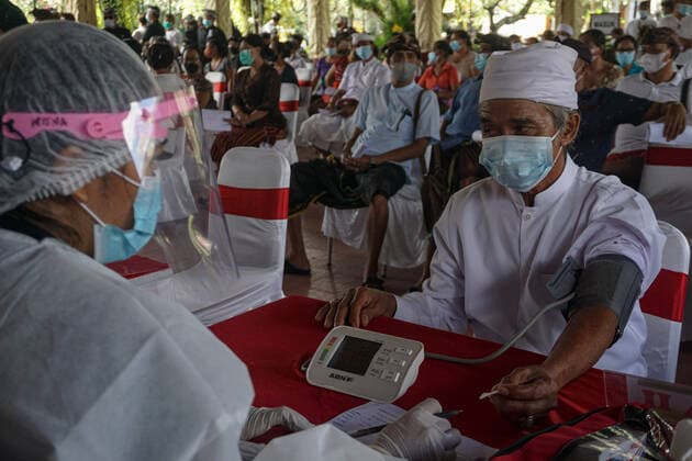 Coronavirus in Indonesien, Präsident Joko Widodo bei Impfstart in Gianyar, Bali March 16, 2021, Gianyar, Bali, Indonesia: A health worker checks a health condition of a Balinese Hindu religious leader before the vaccination. A mass Covid-19 vaccination towards citizens held in Ubud Great Palace, as a stage of Green Zone program in Bali. The Green Zone program involves three region in Bali; Ubud, Sanur and Nusa Dua, are sets to prepare international tourism reopening plan, which falls amid the outbreak. Gianyar Indonesia - ZUMAb245 20210316_zip_b245_024 Copyright: xDickyxBisinglasix