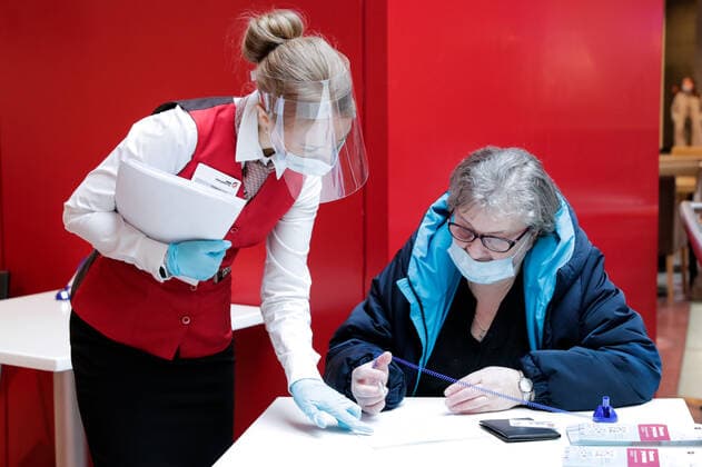 MOSCOW, RUSSIA - MARCH 17, 2021: A My Documents public service centre employee helps a woman fill in her consent form at a temporary COVID-19 vaccination site, a mobile team administering the Gam-COVID-Vac (Sputnik V) vaccine free of charge and without prior appointment at the Kuntsevo Plaza shopping centre in western Moscow. Mikhail Metzel TASS  TS0F99B4