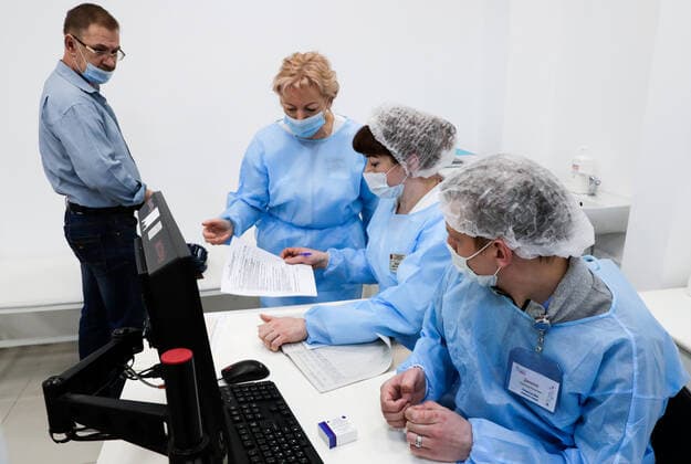 MOSCOW, RUSSIA - MARCH 17, 2021: Members of staff work at a temporary COVID-19 vaccination site, a mobile team administering the Gam-COVID-Vac (Sputnik V) vaccine free of charge and without prior appointment at the Kuntsevo Plaza shopping centre in western Moscow. Mikhail Metzel TASS  TS0F99B6