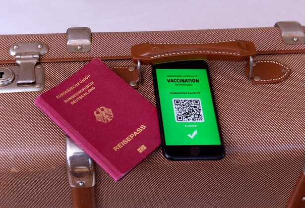 17.03.2021, Symbolbild, Impfung. Ein imaginärer Impfpass in digitaler Form auf dem Smartphone iPhone, bereitgelegt auf einem Reisekoffer mit einem Reisepass. Der digitale Impfpass würde wieder uneingeschränktes Reisen ermöglichen, 17.03.2021, Elektronischer Impfpass für Urlaubsreisen 17.03.2021, Elektronischer Impfpass für Urlaubsreisen