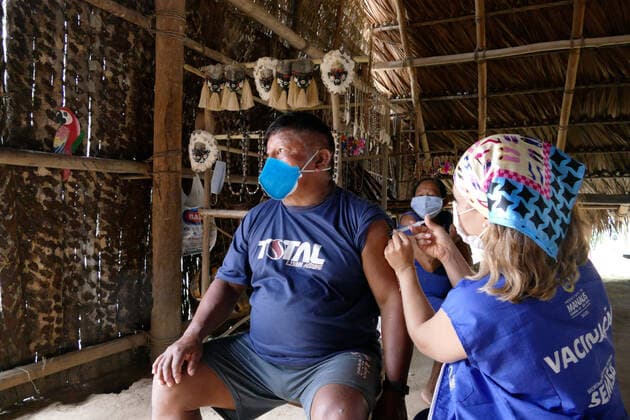 MANAUS, AM - 17.03.2021: VACINAÇÃO DE INDÍGENAS RIBEIRINHOS NO AM - indigenous people of the Tatuyo and Cipia ethnic groups, who live in the riverside community of Araras, are vaccinated against Covid-19, this Wednesday morning (17). In the photo, the chief of the Cipia tribe, Domingos Savio Veloso, 60, is vaccinated with the Oxford AstraZeneca immunizer. x2043629x  SandroxPereira