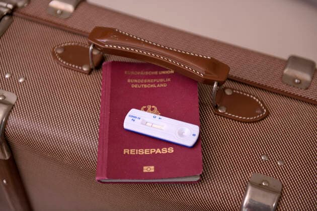 17.03.2021, Symbolbild, Deutscher Reisepass zusammen mit einem Negativen Schnelltest-Ergebnis, bereitgelegt auf einem Reisekoffer 17.03.2021, Reisepass und Negativer Corona-Test 17.03.2021, Reisepass und Negativer Corona-Test