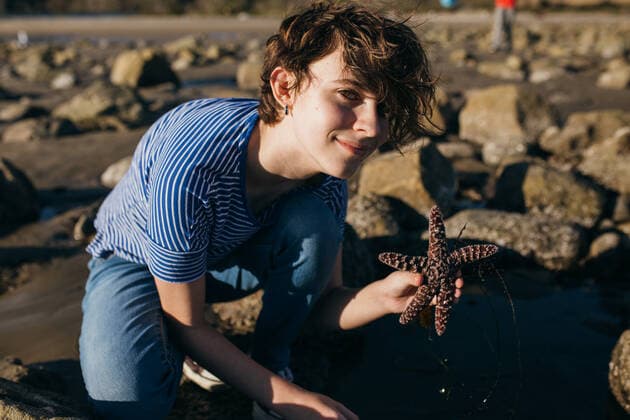 Teen Girl Holds A Starfish At The Beach During Low Tide Malibu, CA, United States CR_ANWHER210318-680467-01 ,model released, Symbolfoto