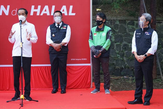 President Joko Widodo Reviewing Drive Thru Vaccination In Bogor, Indonesia Indonesian President Joko Widodo (left) with West Java Governor Ridwan Kamil (left two) and Vice Mayor of Bogor City Dedie Rachim (right) speaks to journalists during COVID-19 vaccination at a drive-thru service in Bogor City, West Java, Indonesia on March 19, 2021. President Joko Widodo hopes that other region in Indonesia will be able to imitate the drive thru vaccination model in Bogor City. 