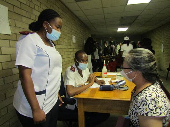 (210319) -- WINDHOEK, March 19, 2021 -- A woman is checked by healthcare workers to see her eligibility for the COVID-19 vaccine in Windhoek, capital of Namibia, March 19, 2021. (Photo by Xinhua) NAMIBIA-WINDHOEK-COVID-19-VACCINATION MusaxCxKaseke 