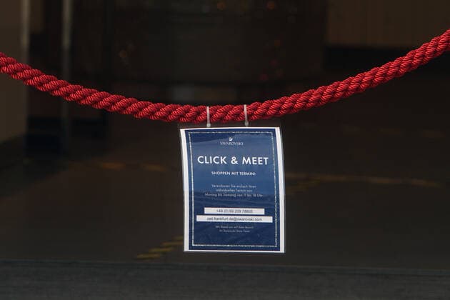 Schild mit Aufschrift Click & Meet Einkaufen mit Termin hängt an einer roten Absperrkordel vor einer geöffneten Svarowski Filiale in der Fußgängerzone und Einkaufsstraße Zeil der Innenstadt Frankfurt, Hessen, Deutschland