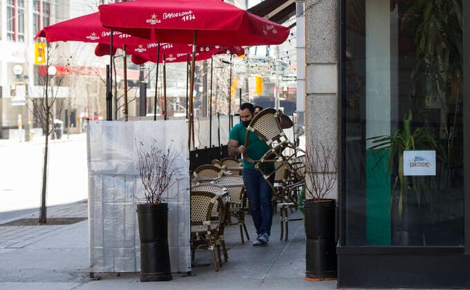 (210320) -- TORONTO, March 20, 2021 -- A waiter wearing a face mask prepares chairs for customers at the outdoor area of a restaurant in Toronto, Canada, on March 20, 2021. With distancing rules and a number of other public health and workplace safety measures, outdoor dining was allowed to resume Saturday in Toronto under modifications to the Ontario s color-coded pandemic response framework. (Photo by Xinhua) CANADA-TORONTO-COVID-19-OUTDOOR DINING-RESUME ZouxZheng 