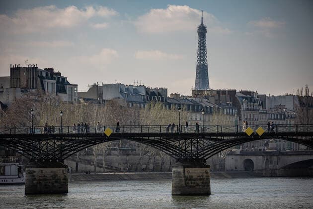 (210320) -- PARIS, March 20, 2021 -- People walk on the Pont des Arts bridge in Paris, France, on March 20, 2021. French Prime Minister Jean Castex on Thursday announced new massive measures to curb COVID-19 in the country s 16 worst-hit regions, including Paris. Starting Friday midnight, about 18 million French people in regions such as Paris, Hauts-de-France in the north as well as the Alpes-Maritimes on the Mediterranean should stay at home, Castex announced at a press briefing on the epidemic situation. (Photo by Xinhua) FRANCE-PARIS-COVID-19-PARTIAL LOCKDOWN AurelienxMorissard 